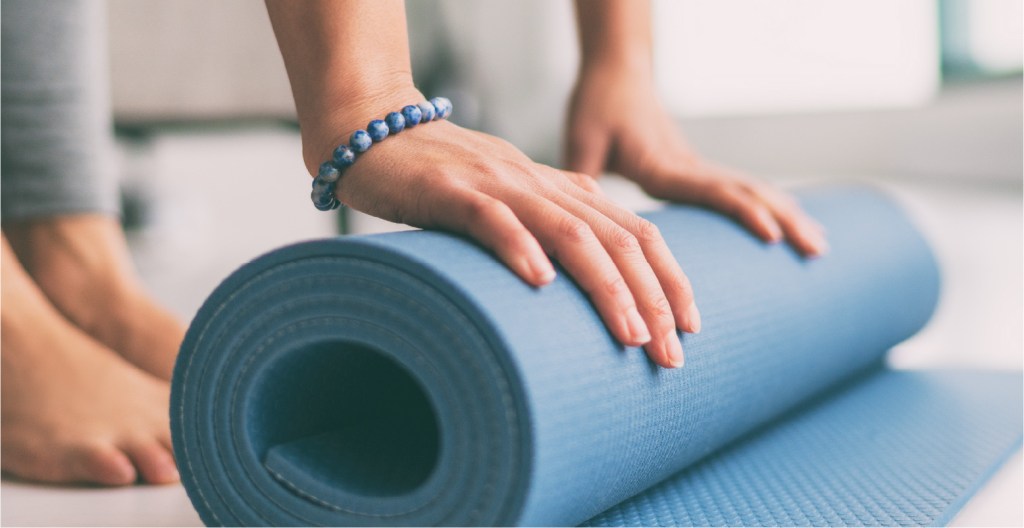 A person rolling a yoga mat